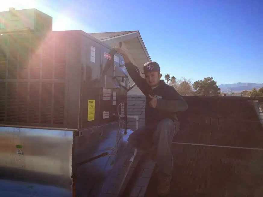 HVAC technician performing Boiler Repair on a rooftop unit in Oatfield